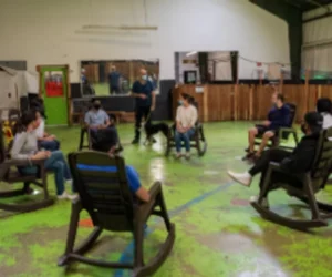 Group training session at Dan Perata Training with seated participants in a spacious indoor facility.
