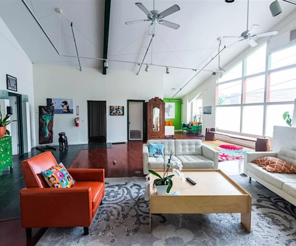 Modern art gallery with colorful paintings and comfortable seating area.