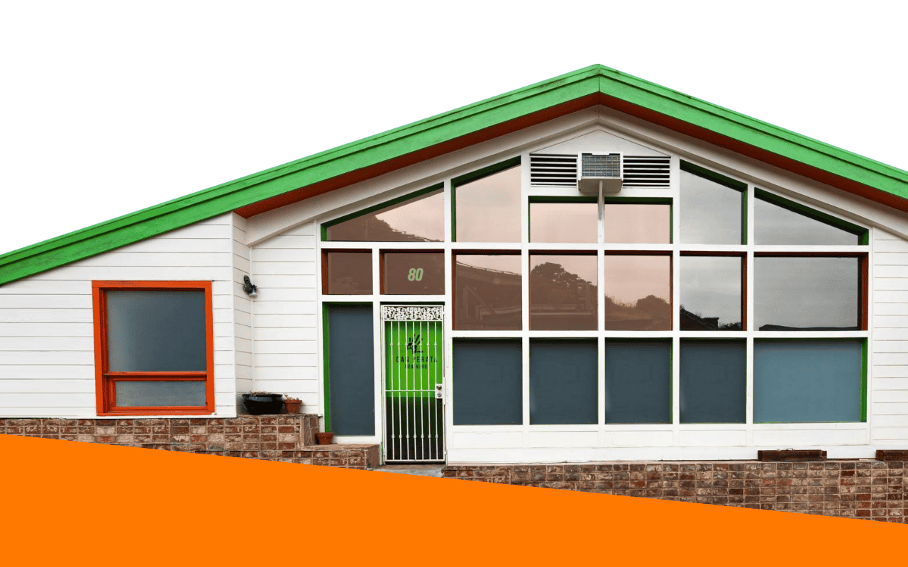 Modern training facility with large glass windows and green roof.