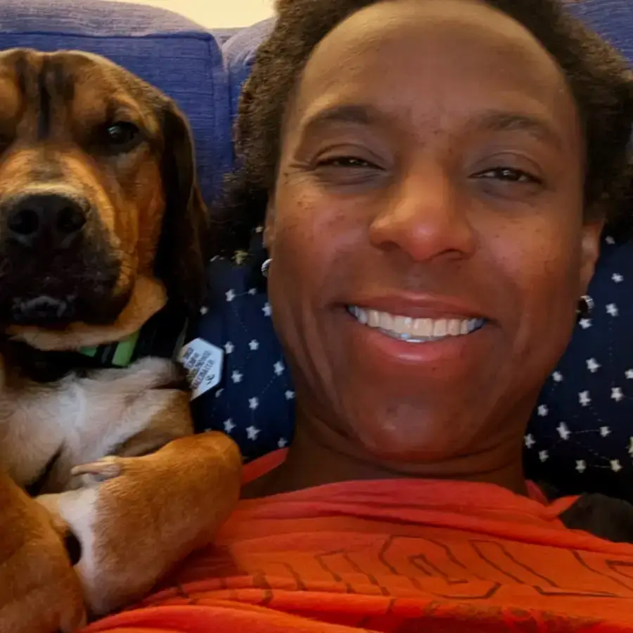 Leo, a dachshund–pit bull mix, cuddled beside his owner Lauren on a couch.